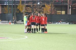 The Rutgers University-Newark women's soccer team meets in a huddle.